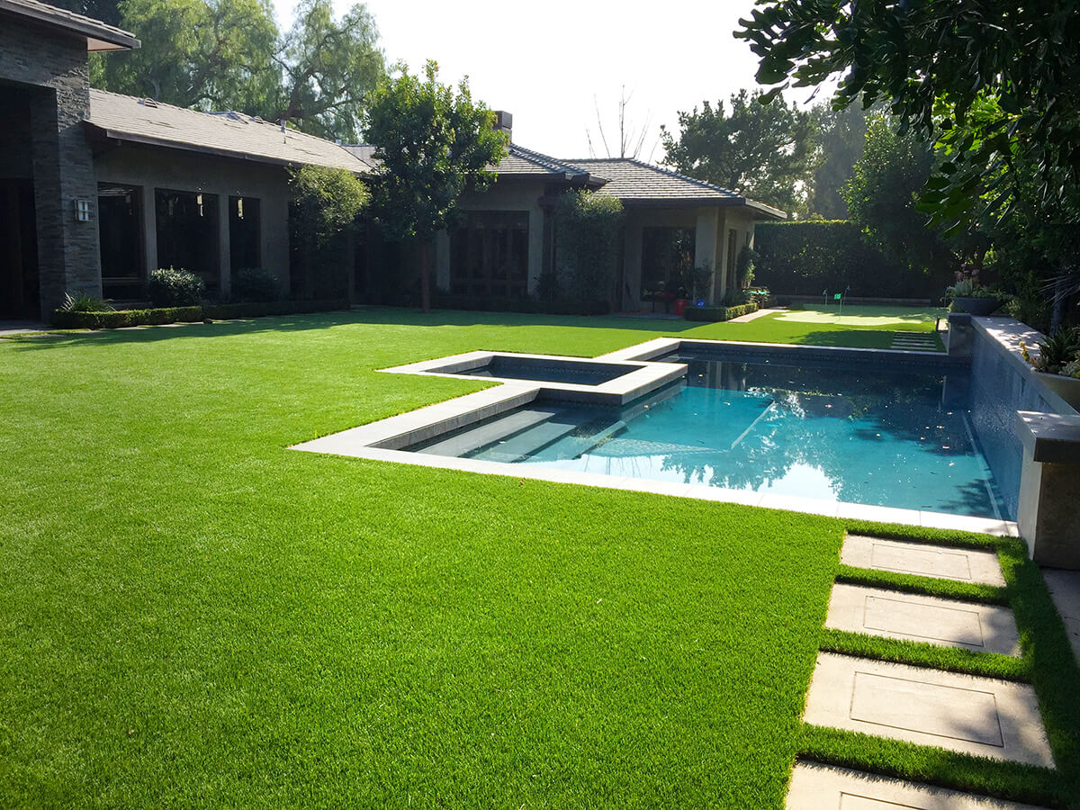 Backyard artificial turf install photo with small pool