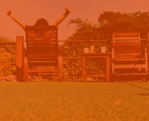 Person relaxing while sitting on chairs in lawn