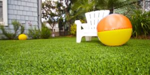 Residential artificial grass with white chair and beach ball
