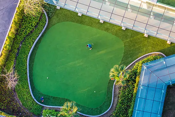 Golfer practicing backyard golf green